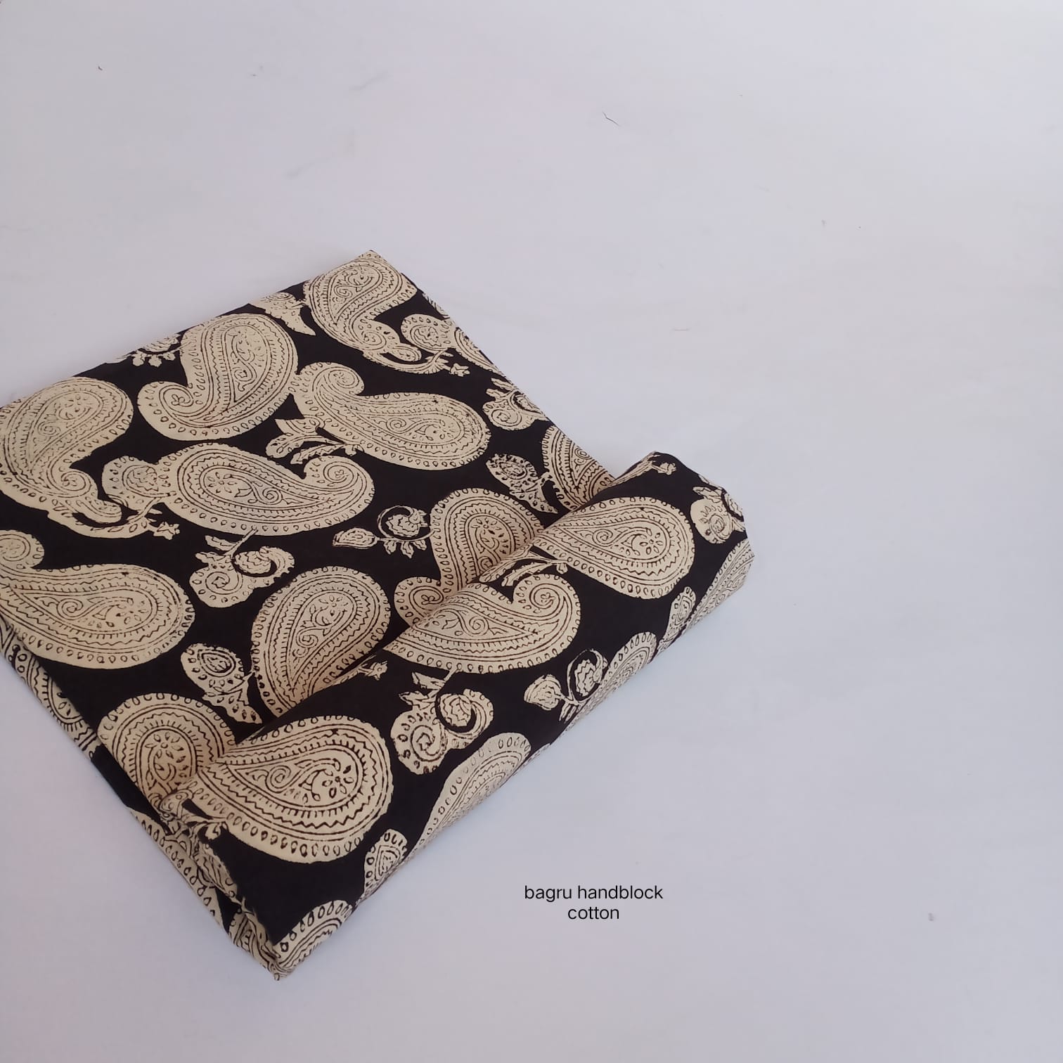 Pure cotton Bagru handblock printed fabric in black with bold paisley motif, artisan-made wholesale textile by Fabtexs